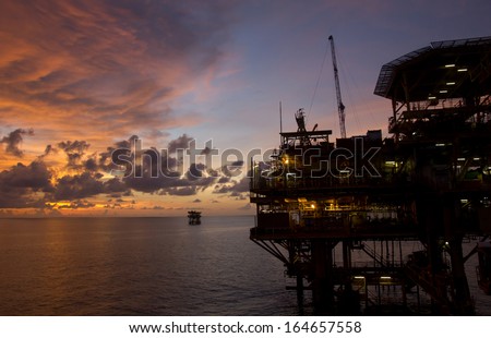 Silhouette of an offshore oil rig at sunset