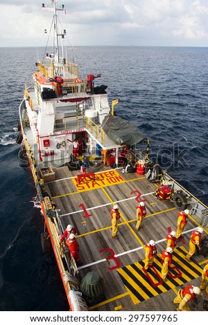 SOUTH CHINA SEA, BRUNEI - OCTOBER 31, 2013: Rig workers are transported on a vessel to offshore rigs in The South China Sea, Brunei on October 31, 2013. A swing rope is used to enter the platform