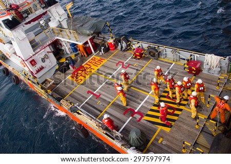 SOUTH CHINA SEA, BRUNEI - OCTOBER 31, 2013: Rig workers are transported on a vessel to offshore rigs in The South China Sea, Brunei on October 31, 2013. A swing rope is used to enter the platform
