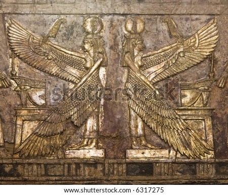 Ancient Egyptian wood relief carving of two winged women, gold gilded