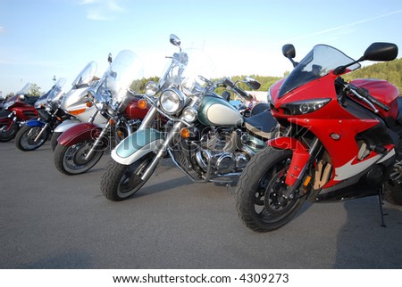 Motorcycles stand in a line on road