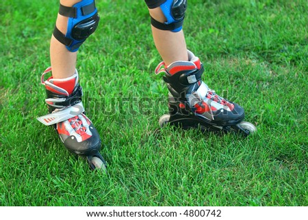 Roller skates dressed on the boy a background of grass
