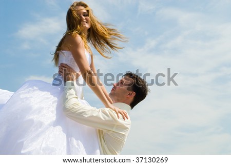 Portrait of the groom and bride on a background sky