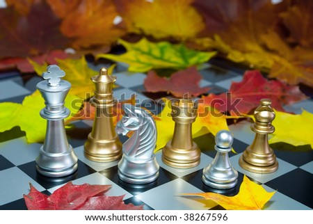 Chess combination on a board and autumn leaves