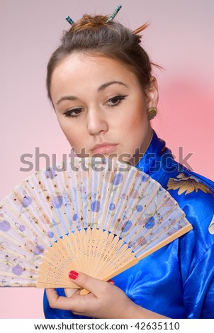 Portrait of the girl in national clothes and with a fan