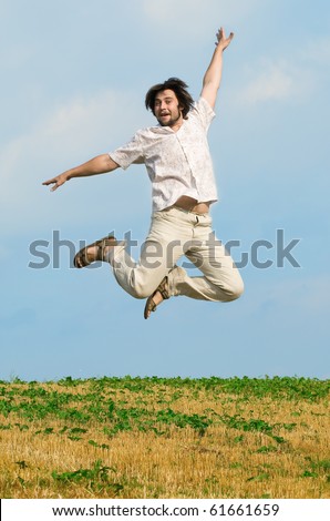 The young man in a jump on summer field