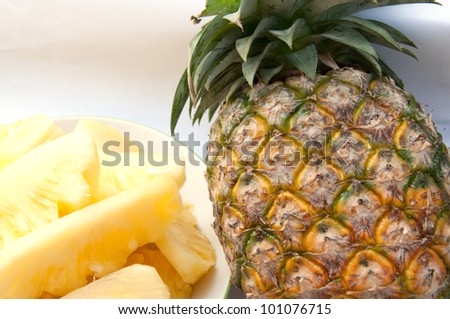 Dish with slices of pineapple on a white background.