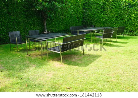 business patio with table and chairs in garden
