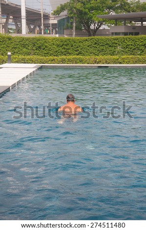 old man swimming in the swimming pool