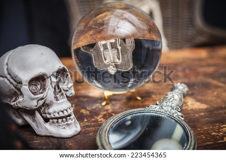 Skull, old mirror and crystal ball with reflection skeleton. Halloween.