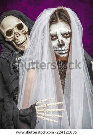 Young woman a bride in a veil day of the dead mask skull face art and skeleton. Halloween face art.