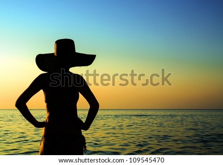 Female silhouette by the sea at dusk