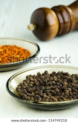 Close-up shot of black peppercorns on white kitchen table - selective focus