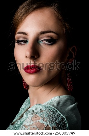 Close up Face of an Elegant Young Woman with Make up Staring to the Bottom Right of the Frame on a Black Background.