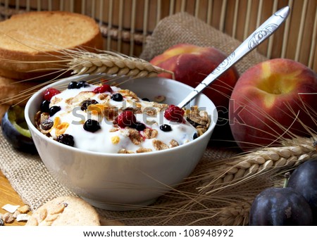 bowl of muesli with raisins and berry fruits, toast and peaches,healthy breakfast rich in fiber
