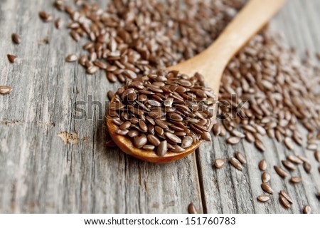 wooden spoon with flax seed placed on a wooden table