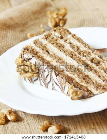 Cake Slice with Nuts Layers and Mascarpone Cream Decorated with Whole Nuts