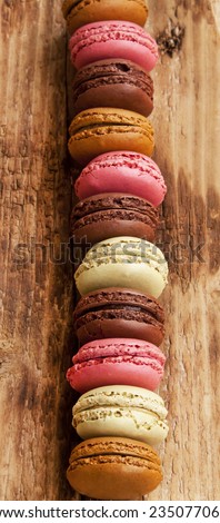 Delicious Macarons, French Pastry Cookies with Cream on Wooden Board Placed Over Each Other