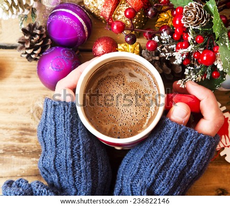 Warm Hands Holding Chocolate Cup with Christmas Decorations