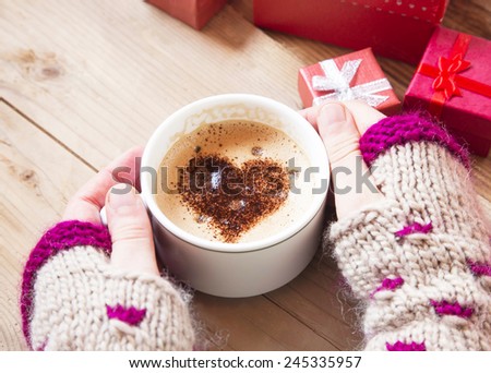 Hands Holding Warm Cappuccino with Froth and Cocoa Heart Shape