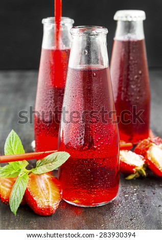 Refreshing Red Juice with Strawberries and Mint in Transparent Bottles with Straws