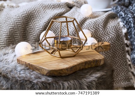 Home deco indoor with candle holder and light bulbs, cozy blanket and faux fur,cozy winter interior details