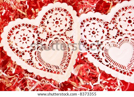 Two white lace heart on red and white background