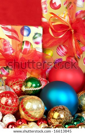 Colorful Christmas tree ornaments and presents focus on the foreground, blurred background