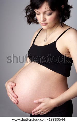 stock photo Young and pretty brunette pregnant woman with big belly