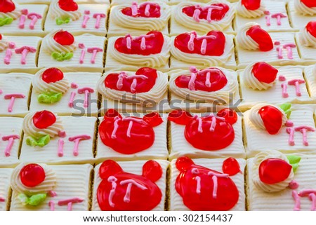 Delicious small fancy cakes decorated with bear, heart  and IT text