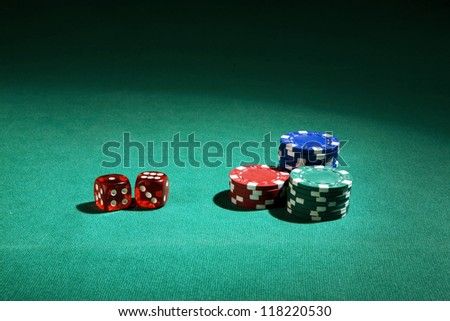 dice with chip on green table in soft ambient