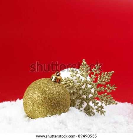 Christmas ball and snowball on the snow and red background