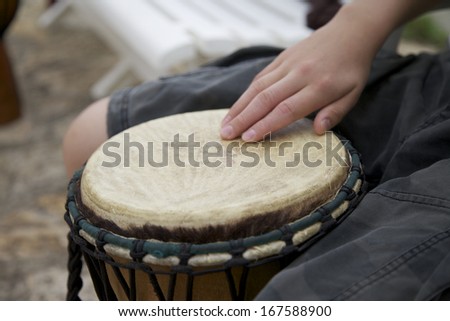 African Drum with a hand on a skin of the drumhead. An Instrument for Percussionists and Musicians.