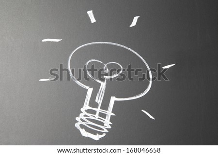scribble of a light bulb on a chalkboard. Abstract scribble with a white outline of a light bulb.