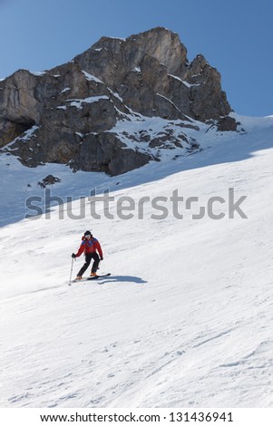 Skier on hard packed snow below chute.