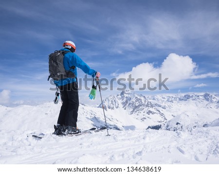 Skier looking out over mountain landscape.