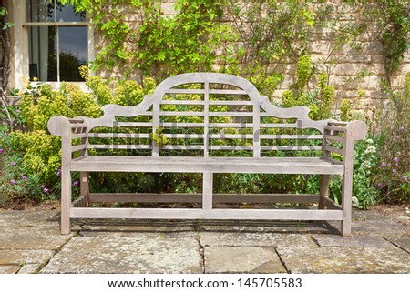 Old garden bench situated in a landscaped garden.