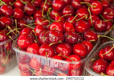 Colorful display of ripe cherries at a food market.