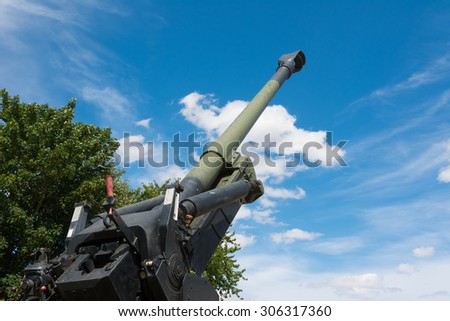 Howitzer gun barrel pointing skyward in threat.