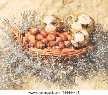 Christmas background: braided basket full of hazelnuts and Christmas balls