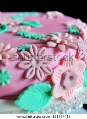 Cake design, detail of sugar paste flowers on pink cake