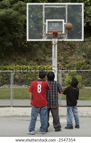 three boys plying basketball