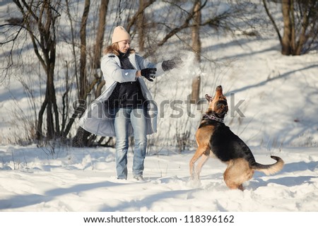 Girl playing with dog on the snow