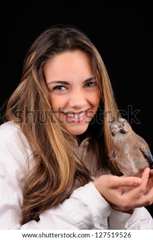 Portrait of smiling girl with bird on the hand