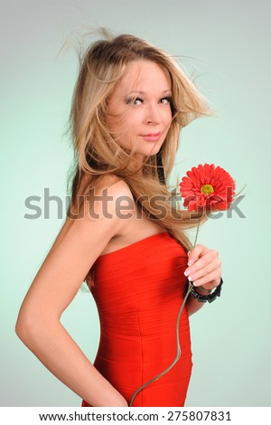 Beautiful portrait of woman with red floweron the green blurred background
