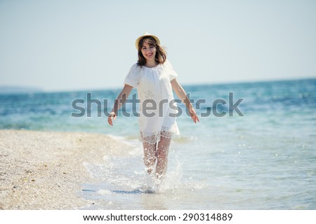 happy girl in white dress  running on the sea beach