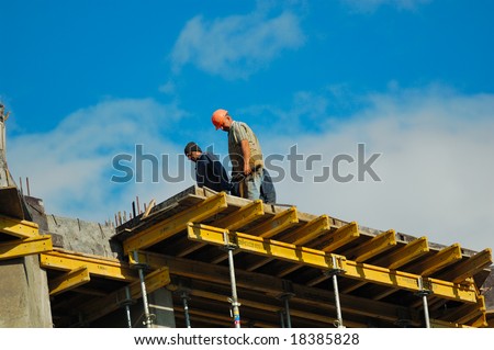 2 workers on the roof of construction