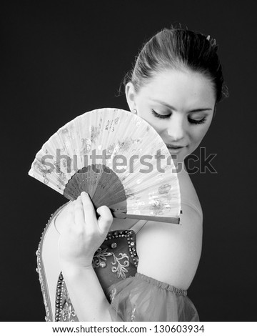 Black and white portrait of ballerina posing with a hand held fan