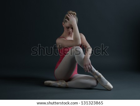 Ballerina sitting on floor thinking with her hand on her head