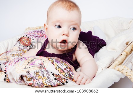 Cute baby lying in a basket and enjoy long slobber admits. - stock-photo-cute-baby-lying-in-a-basket-and-enjoy-long-slobber-admits-103908062